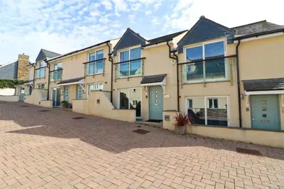 a row of houses on a brick street at BEACHSIDE modern home, dogs welcome in St Merryn