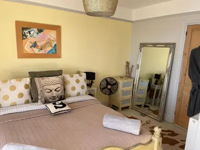 a bedroom with a large bed and a mirror at Seaforth St Ives in St Ives
