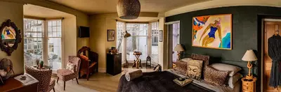 a living room with a bed and some chairs at Seaforth St Ives in St Ives