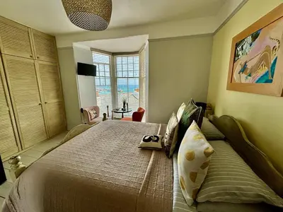 a bedroom with a large bed and a window at Seaforth St Ives in St Ives