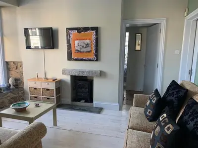 a living room with a couch and a fireplace at Seaforth St Ives in St Ives