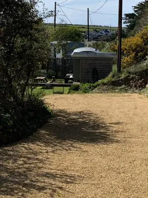 a park with a bench and a shed on a hill at Tides Reach, Deluxe Shepherds hut 1, 100m from the Beach in St Merryn
