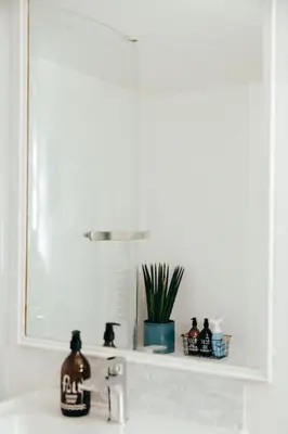 a bathroom sink with a mirror and a bottle on it at The Hideout - Newquay - Fully Stocked Eco Escape in Newquay