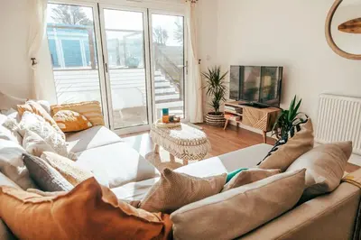 a living room with a couch and a television at The Hideout - Newquay - Fully Stocked Eco Escape in Newquay