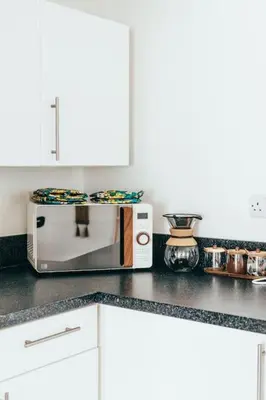 a kitchen counter with a microwave on top of it at The Hideout - Newquay - Fully Stocked Eco Escape in Newquay