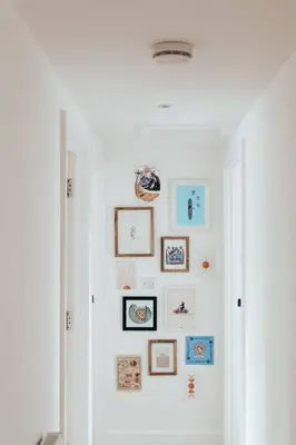 a hallway with a bunch of pictures on a wall at The Hideout - Newquay - Fully Stocked Eco Escape in Newquay