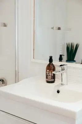 a bottle of soap sitting on top of a bathroom sink at The Hideout - Newquay - Fully Stocked Eco Escape in Newquay