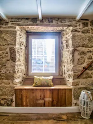 a window in a stone room with a bench in front of it at Knocker Cottage is a 3 bedroom made up of 1 double bedroom and 2 small double bedrooms in small village 10 min to beaches in Camborne