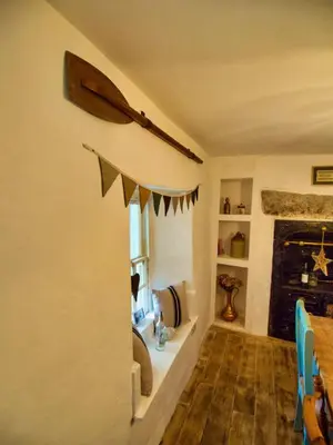 a living room with a fireplace and a flag on the wall at Knocker Cottage is a 3 bedroom made up of 1 double bedroom and 2 small double bedrooms in small village 10 min to beaches in Camborne