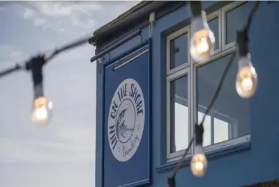 a blue building with lights on the side of it at Torpoint - Apartment - Sleeps4 - Seaside - Parking in Torpoint