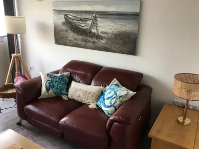 a brown leather couch in a living room with a painting at Torpoint - Apartment - Sleeps4 - Seaside - Parking in Torpoint
