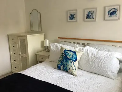 a bedroom with a bed with a blue pillow on it at Torpoint - Apartment - Sleeps4 - Seaside - Parking in Torpoint