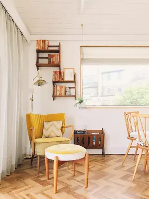 a living room with a yellow couch and a table at Sands Studio and Samphire Studio in St Ives