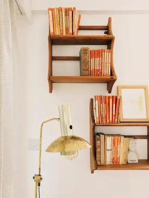 a lamp and bookshelves on a wall at Sands Studio and Samphire Studio in St Ives