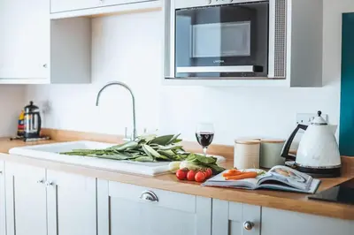 a kitchen counter with vegetables on a cutting board at Beach Lovers Paradise in Portreath - With Sea Views & Log Burner just 100m from beach in Portreath