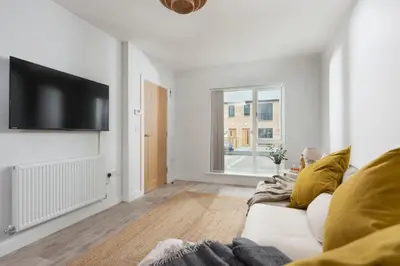a living room with a white couch and a flat screen tv at Towans Retreat, Hayle in Hayle
