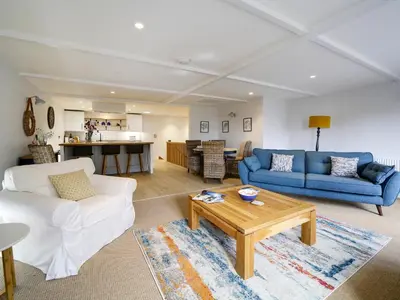 a living room with two couches and a table at Joinery Cottage in Porthleven