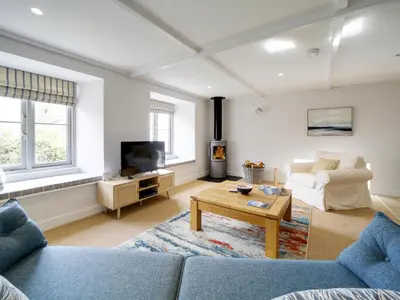 a living room with a couch and a table at Joinery Cottage in Porthleven
