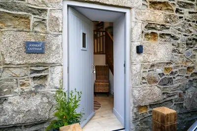 a door into a stone building with a stone wall at Joinery Cottage in Porthleven