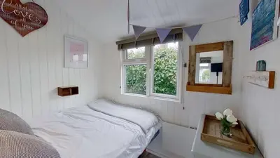 a small bedroom with a bed and a window at F17 Up-A-Bank, Riviere Towans in Hayle