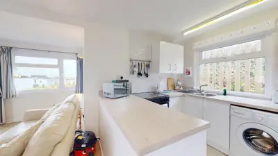a white kitchen with a sink and a counter top at F15 Brian View, Riviere Towans in Hayle