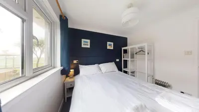 a bedroom with a white bed and a window at F60 Atlantic View, Riviere Towans in Hayle