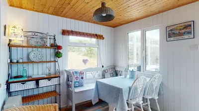 a dining room with a table and chairs at F67 Ischia, Riviere Towans in Hayle