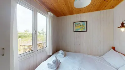 a small bedroom with a bed and a window at F67 Ischia, Riviere Towans in Hayle