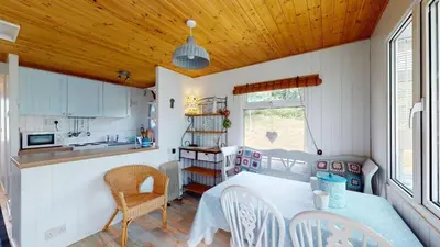 a kitchen and dining room with a table and chairs at F67 Ischia, Riviere Towans in Hayle