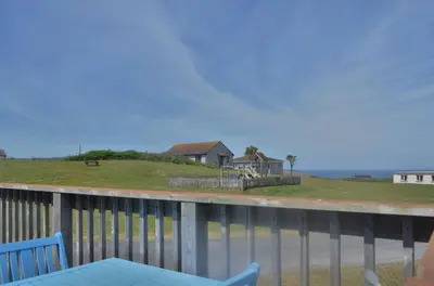 a balcony with a table and chairs and a house at F62 Near Sea, Riviere Towans in Hayle
