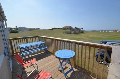 a deck with a blue table and chairs on it at F62 Near Sea, Riviere Towans in Hayle