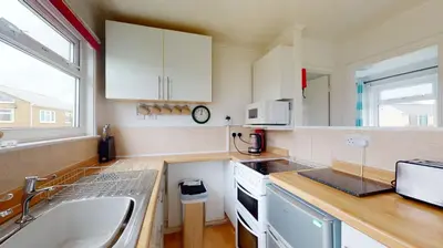 a kitchen with white cabinets and a sink at F62 Near Sea, Riviere Towans in Hayle