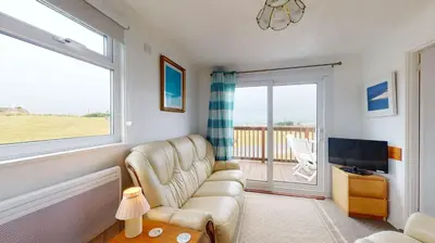 a living room with a couch and a television at F62 Near Sea, Riviere Towans in Hayle