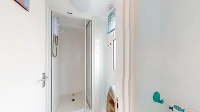 a bathroom with a shower and a mirror at F75 Bronvellan, Riviere Towans in Hayle