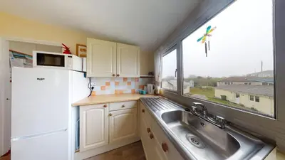 a small kitchen with a sink and a window at F75 Bronvellan, Riviere Towans in Hayle
