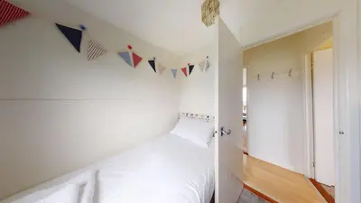 a room with a bed and flags on the wall at F75 Bronvellan, Riviere Towans in Hayle