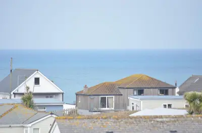 a group of houses with the ocean in the background at F74 Chyandour, Riviere Towans in Hayle