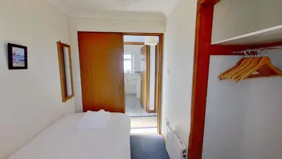 a small room with a bed and a hallway at F74 Chyandour, Riviere Towans in Hayle