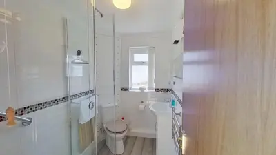 a white bathroom with a toilet and a sink at F74 Chyandour, Riviere Towans in Hayle