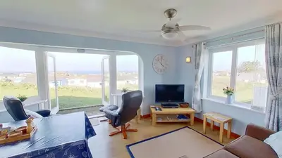 a living room with a couch and a tv at F74 Chyandour, Riviere Towans in Hayle