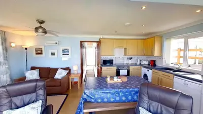 a kitchen and living room with a couch and a table at F74 Chyandour, Riviere Towans in Hayle