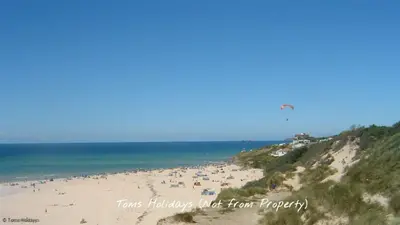 a group of people on a beach flying a kite at G05 Horizon G5, Riviere Towans in Hayle