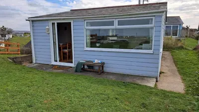 a blue house with a window and a table at F18 Branksea, Riviere Towans in Hayle