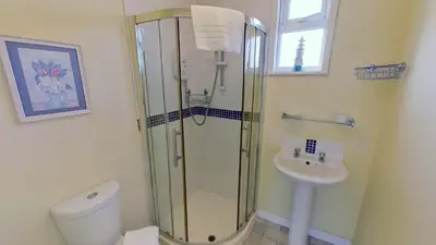 a bathroom with a shower and a toilet and a sink at F18 Branksea, Riviere Towans in Hayle