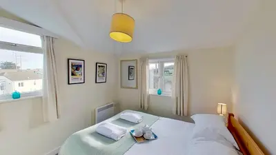 a bedroom with a bed with two pillows on it at F18 Branksea, Riviere Towans in Hayle