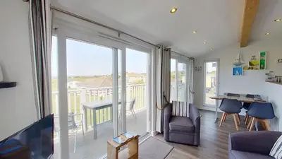 a living room with a large sliding glass door at F55 Begondulkare, Riviere Towans in Hayle