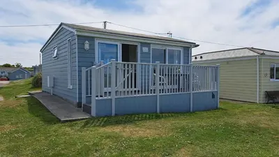 a small house with a porch and a fence at F55 Begondulkare, Riviere Towans in Hayle