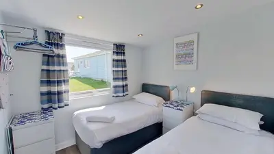 a bedroom with two beds and a window at F55 Begondulkare, Riviere Towans in Hayle