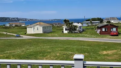 a group of houses on a hill next to a road at F55 Begondulkare, Riviere Towans in Hayle