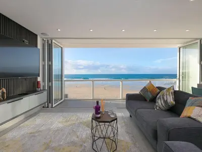 a living room with a couch and a view of the beach at Louies Loft in St Ives